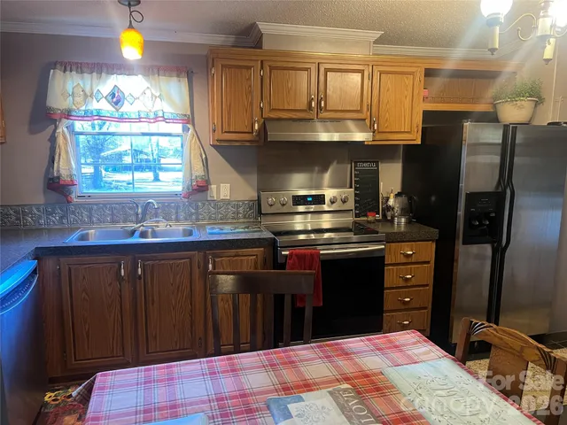 a kitchen with stainless steel appliances granite countertop a refrigerator stove and sink