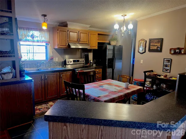 a kitchen with stainless steel appliances granite countertop a sink dishwasher stove and refrigerator with wooden floor