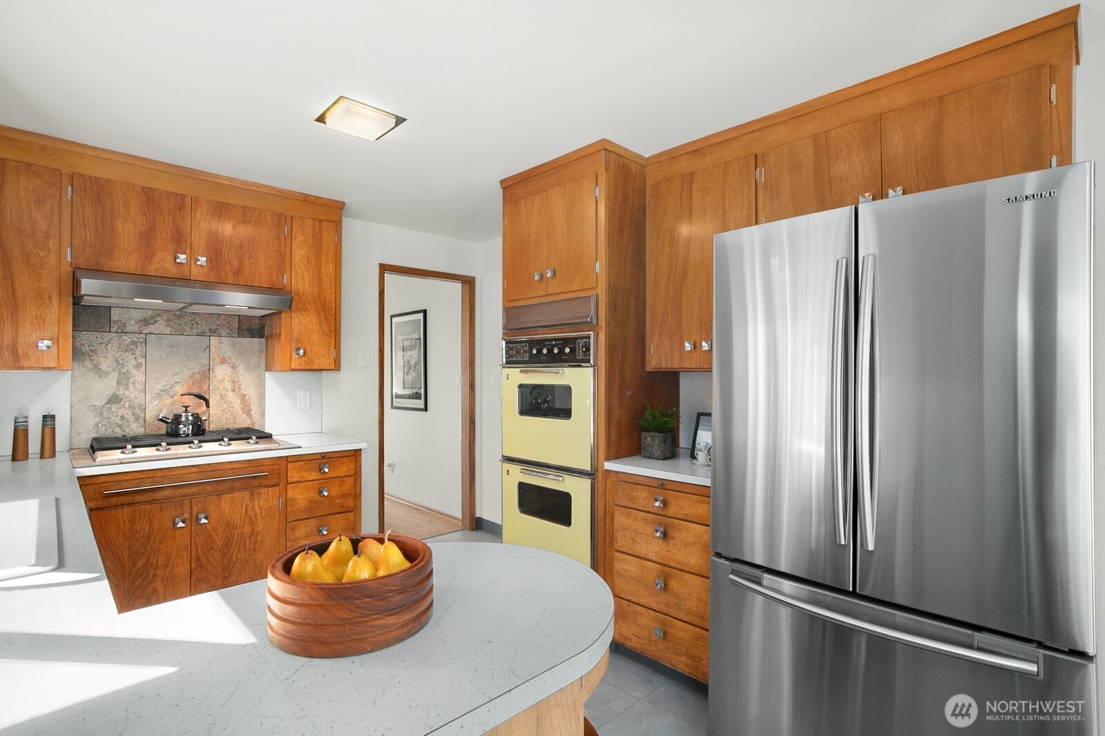 6024 48th Avenue Southwest Seattle, WA 98136 - Photo 7 of 40 a kitchen with stainless steel appliances a refrigerator a sink a stove and cabinets