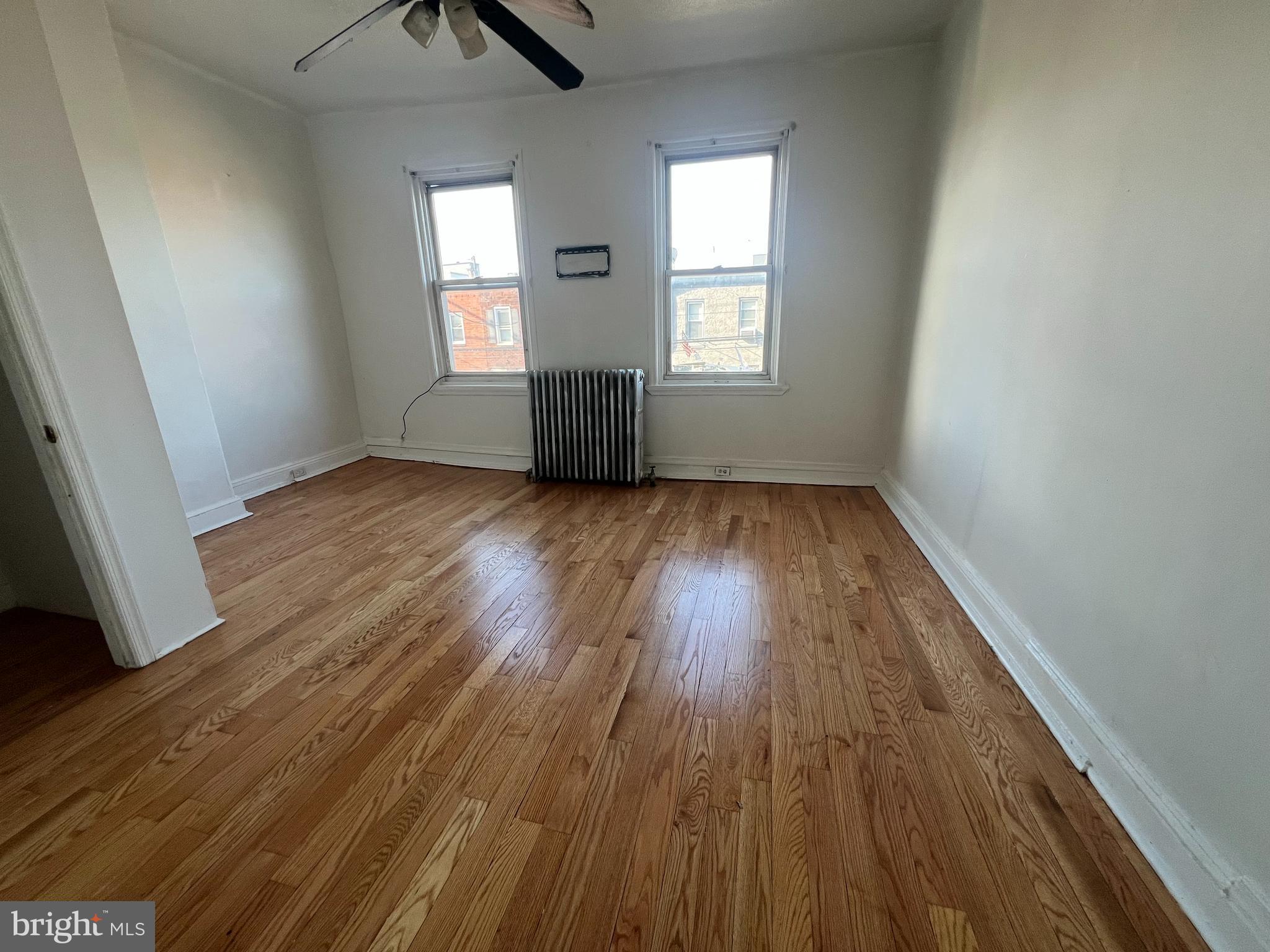 1319 South 22nd Street, Unit 2 Philadelphia, PA 19146 - Photo 2 of 9 an empty room with wooden floor and windows