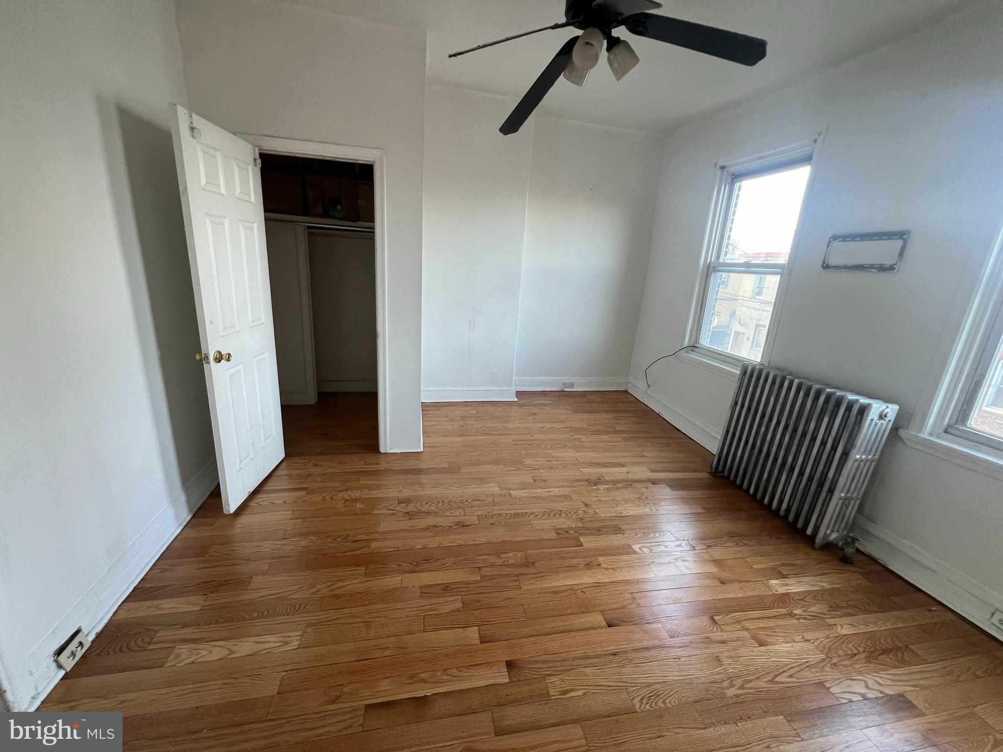 1319 South 22nd Street, Unit 2 Philadelphia, PA 19146 - Photo 6 of 9 an empty room with wooden floor fan and windows