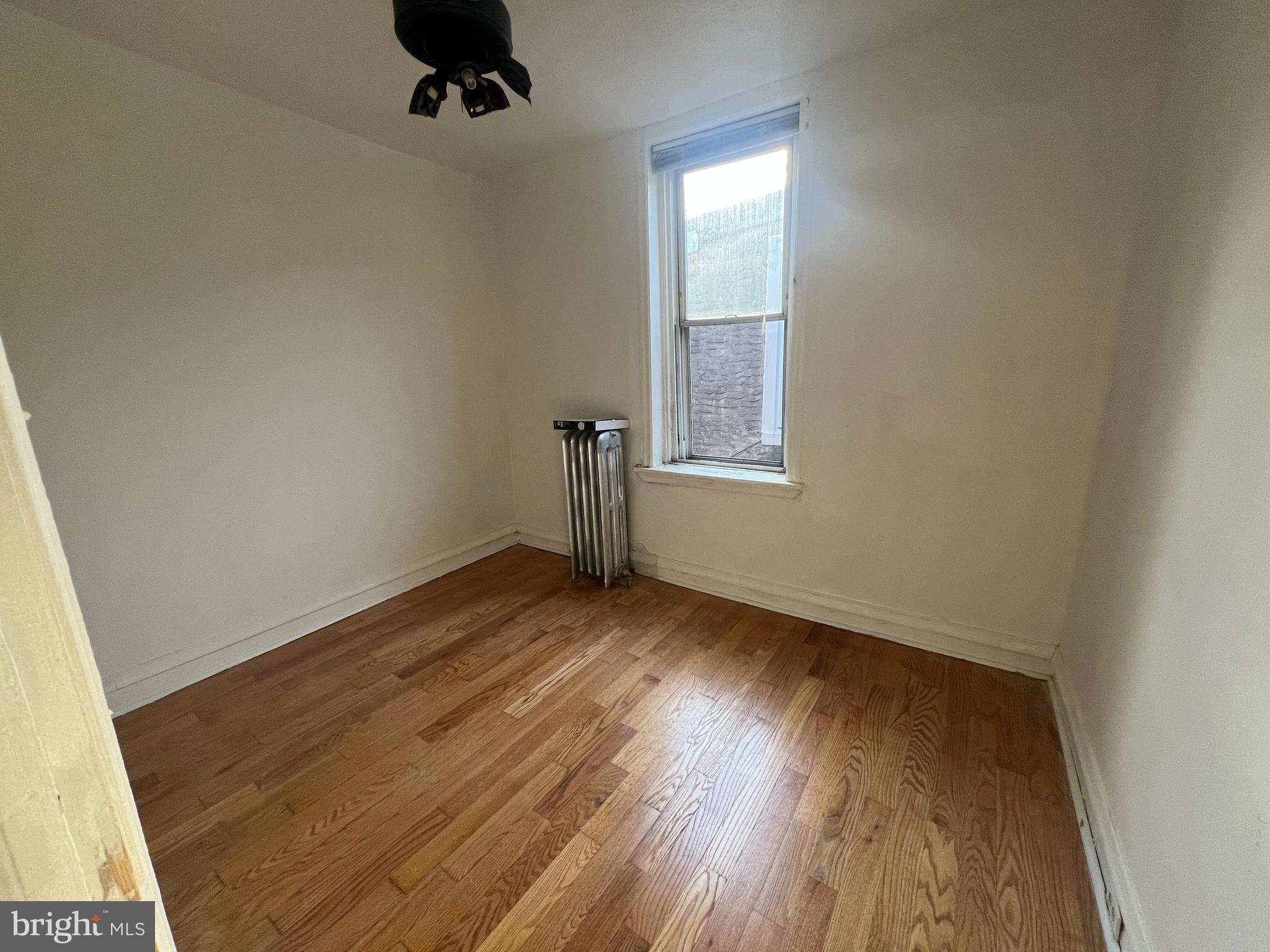 1319 South 22nd Street, Unit 2 Philadelphia, PA 19146 - Photo 7 of 9 an empty room with wooden floor cabinet and windows