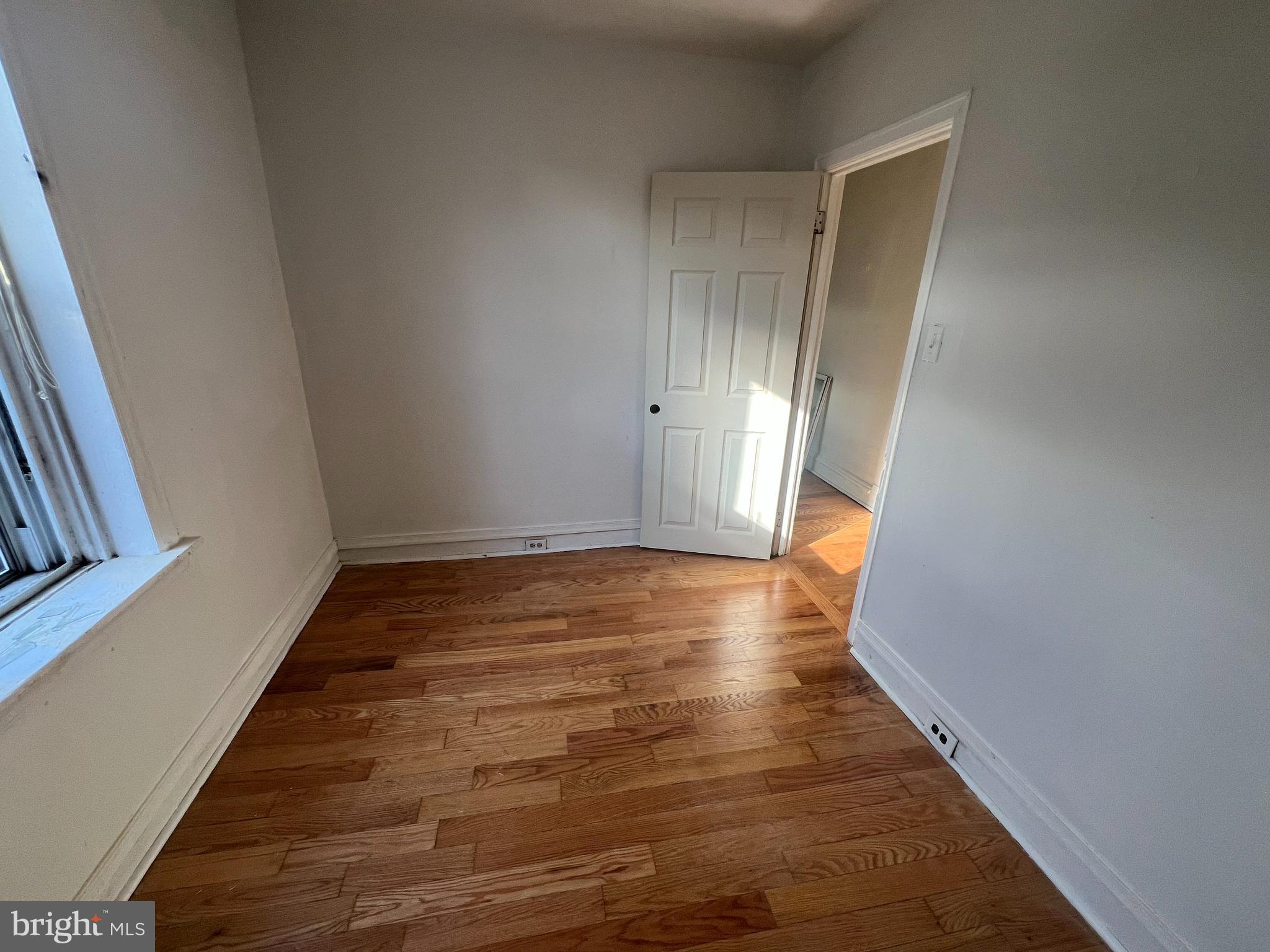 1319 South 22nd Street, Unit 2 Philadelphia, PA 19146 - Photo 8 of 9 a view of an empty room with wooden floor and a window