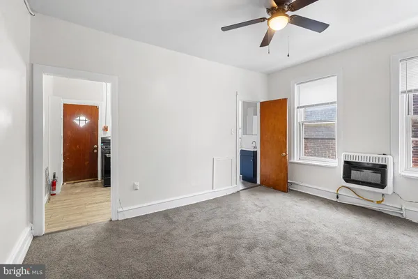 a view of an empty room with a window and a fireplace