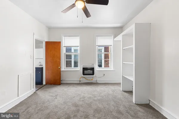 an empty room with closet and windows