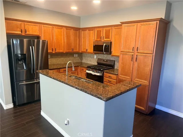 a kitchen with stainless steel appliances a refrigerator and a stove top oven