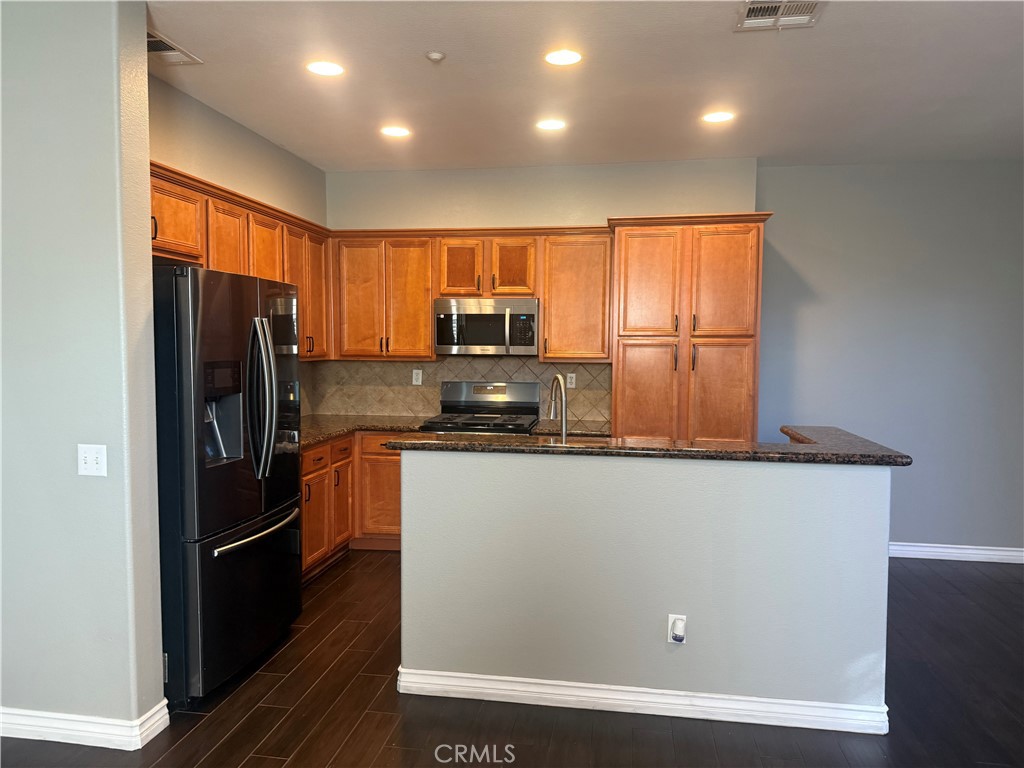 8692 East 9th Street, Unit 38 Rancho Cucamonga, CA 91730 - Photo 12 of 31 a kitchen with stainless steel appliances a refrigerator and a stove top oven
