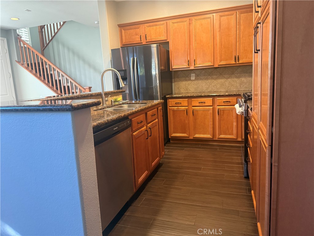 8692 East 9th Street, Unit 38 Rancho Cucamonga, CA 91730 - Photo 13 of 31 a kitchen with stainless steel appliances granite countertop a sink and a refrigerator