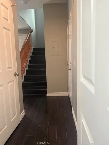 a view of a hallway with wooden floor and staircase
