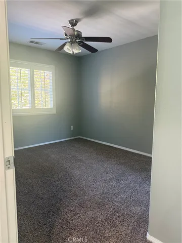 an empty room with fan and entrance