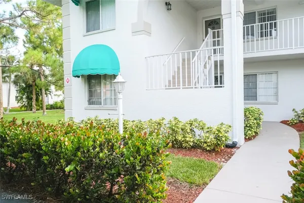 a front view of a house with a yard and potted plants