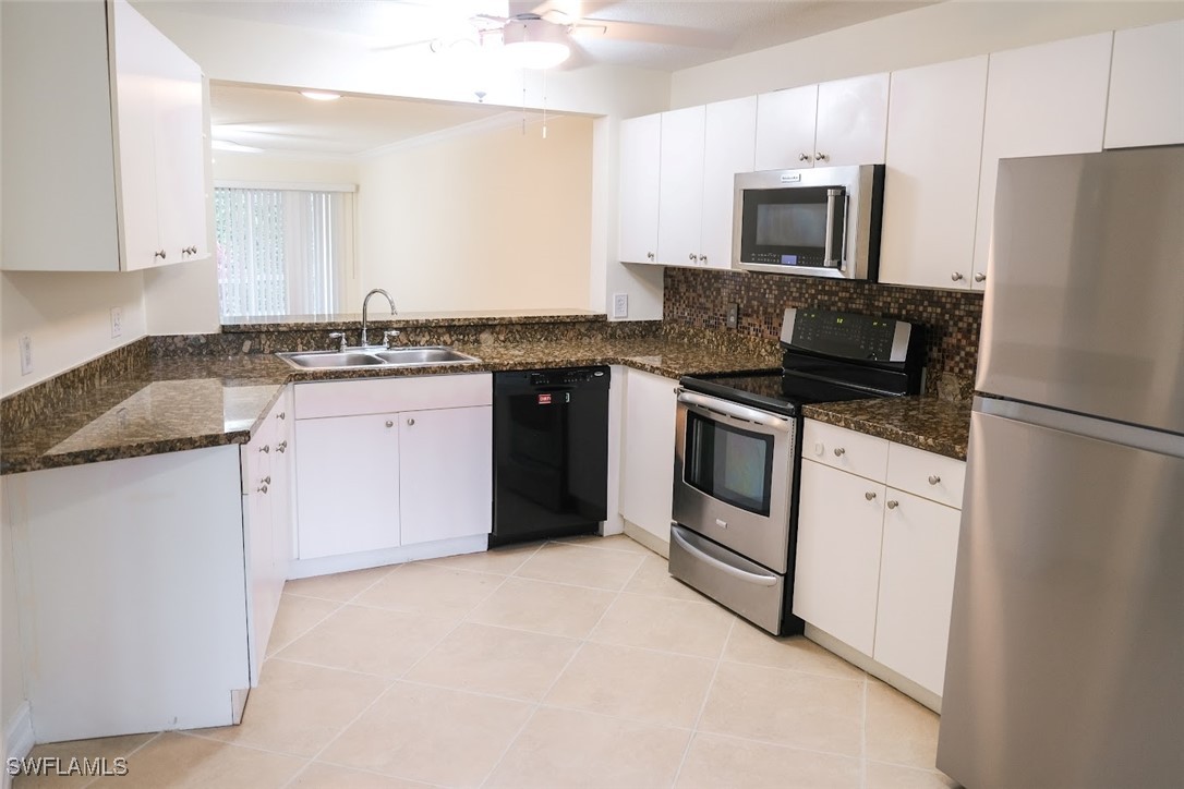 345 Gabriel Circle, Unit 2411 Naples, FL 34104 - Photo 4 of 13 a kitchen with stainless steel appliances granite countertop a stove top oven a refrigerator a sink and dishwasher