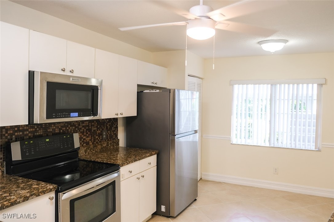 345 Gabriel Circle, Unit 2411 Naples, FL 34104 - Photo 6 of 13 a kitchen with granite countertop a refrigerator stove and microwave