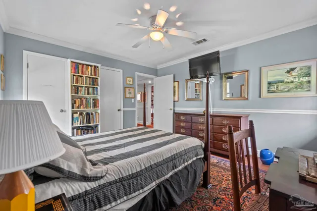 a bedroom with a bed bookshelf and a window