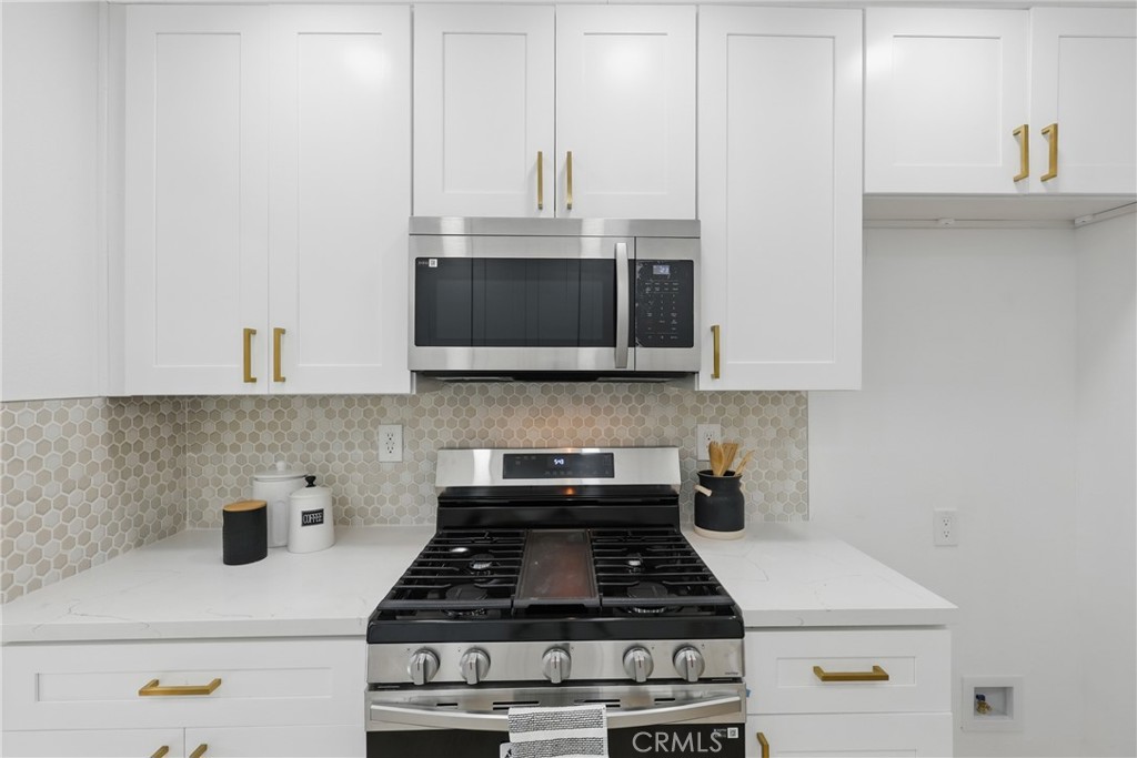 9431 Cypress Avenue Riverside, CA 92503 - Photo 11 of 40 a kitchen with stainless steel appliances a stove a microwave and cabinets