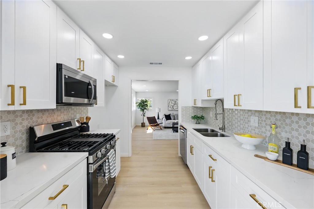 9431 Cypress Avenue Riverside, CA 92503 - Photo 10 of 40 a large kitchen with stainless steel appliances granite countertop a lot of counter space and wooden floors