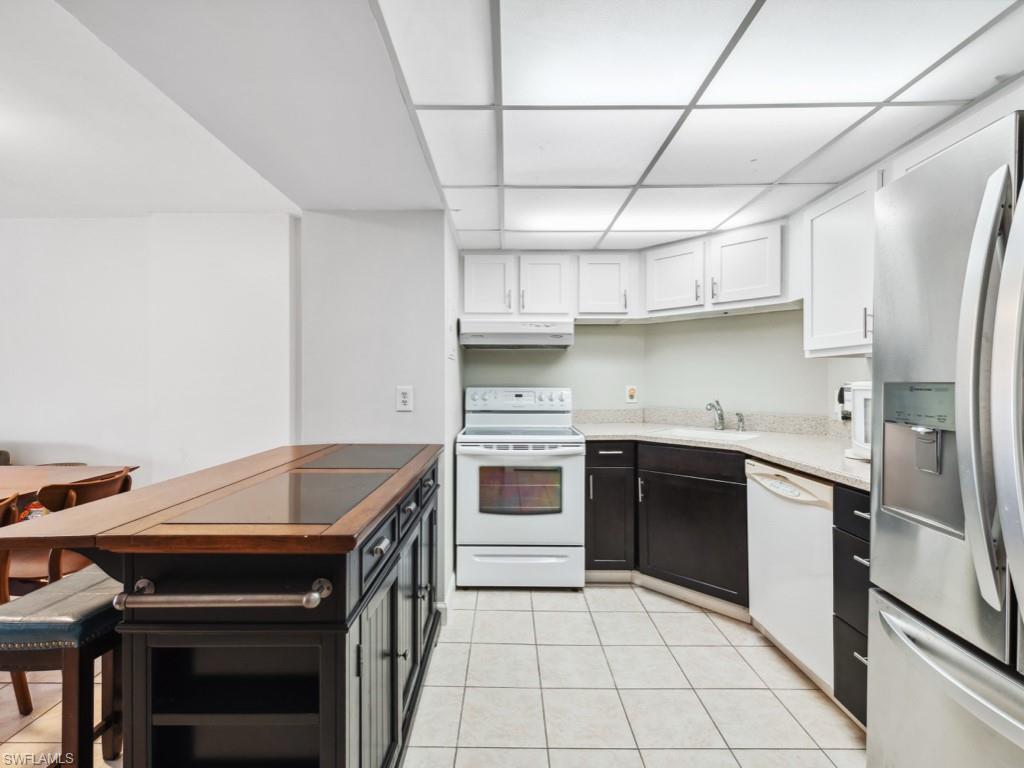3 Bluebill Avenue, Unit 206 Naples, FL 34108 - Photo 7 of 19 a kitchen with stainless steel appliances granite countertop a stove and a refrigerator