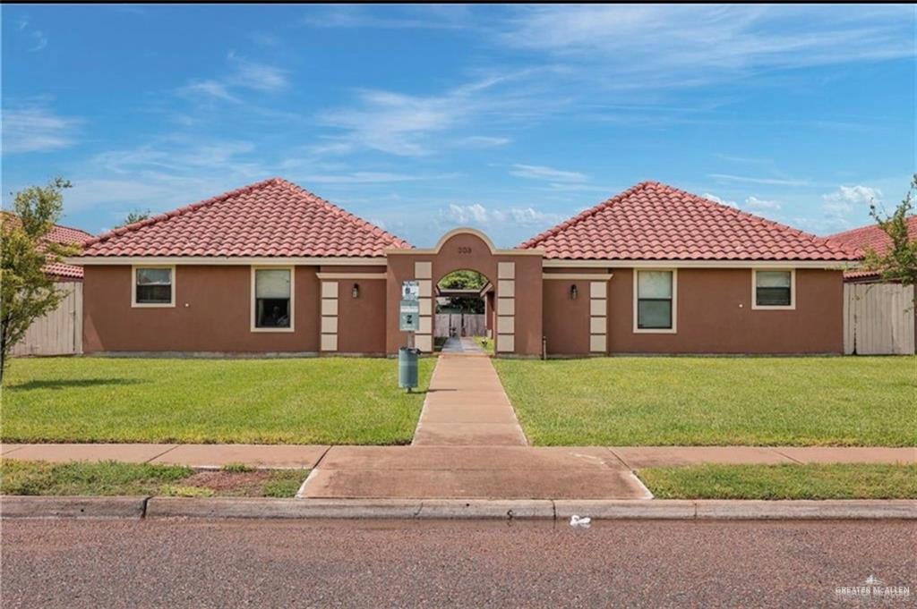 a front view of a house with a garden and yard