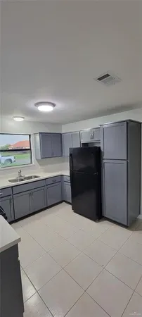a view of an empty room with wooden cabinets