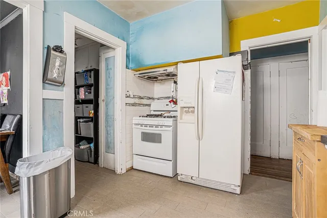 a kitchen with white cabinets and white appliances