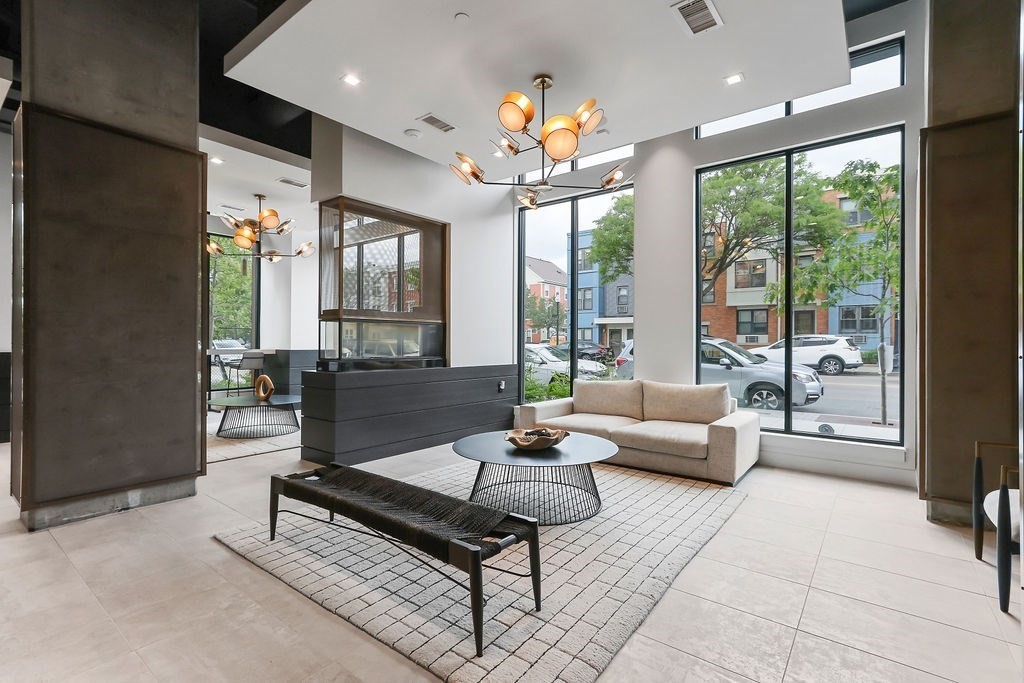 99 Sumner Street, Unit 623 Boston, MA 02128 - Photo 11 of 15 a living room with furniture a chandelier and a large window
