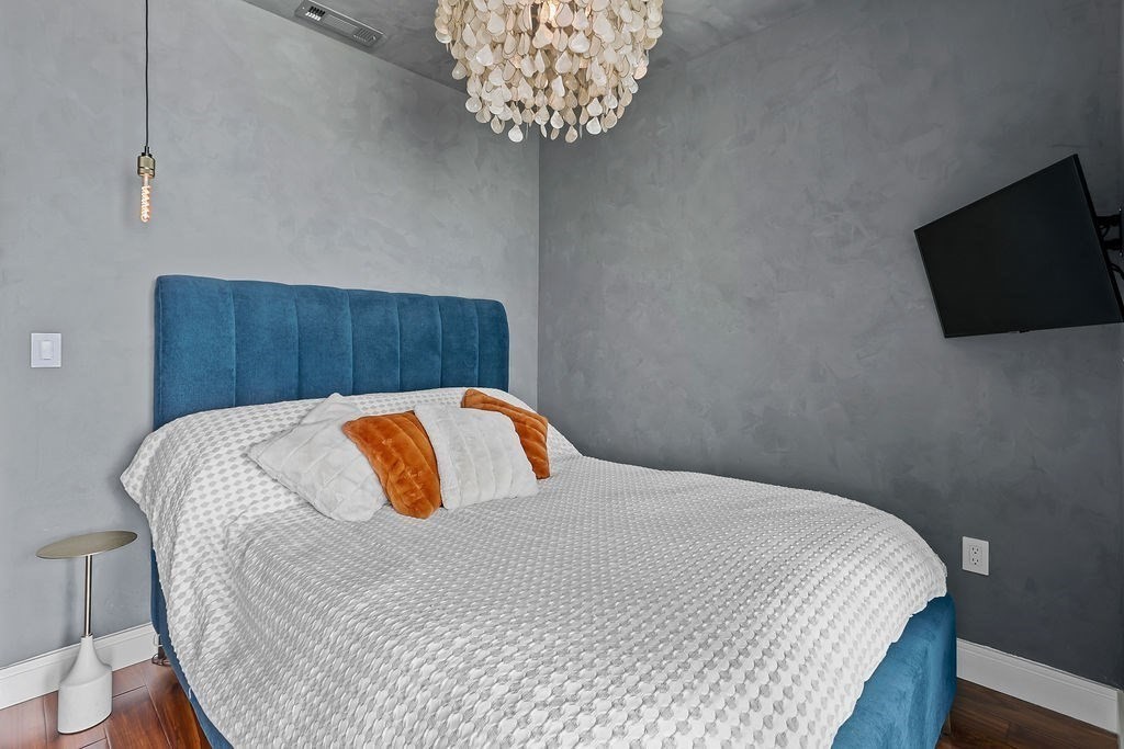 99 Sumner Street, Unit 623 Boston, MA 02128 - Photo 7 of 15 a bedroom with a bed and flat screen tv