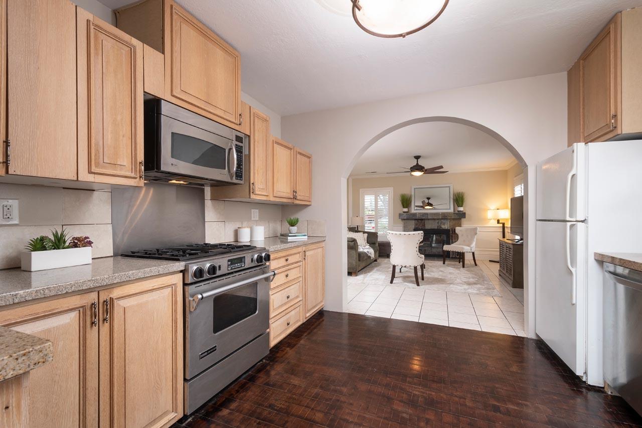 381 Old County Road San Carlos, CA 94070 - Photo 8 of 23 a kitchen with stainless steel appliances granite countertop a stove a sink dishwasher and a microwave with wooden floor