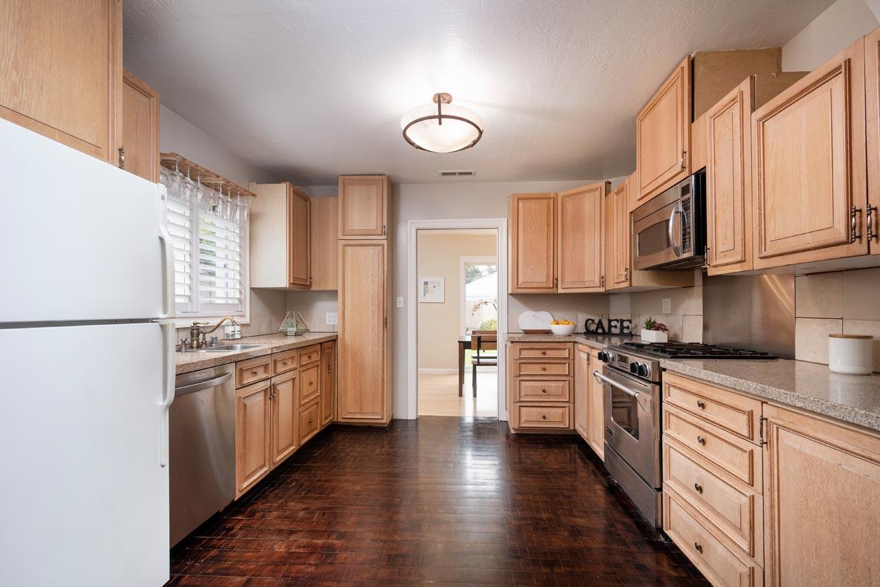381 Old County Road San Carlos, CA 94070 - Photo 9 of 23 a kitchen with stainless steel appliances granite countertop a refrigerator a stove top oven a sink and dishwasher with wooden floor