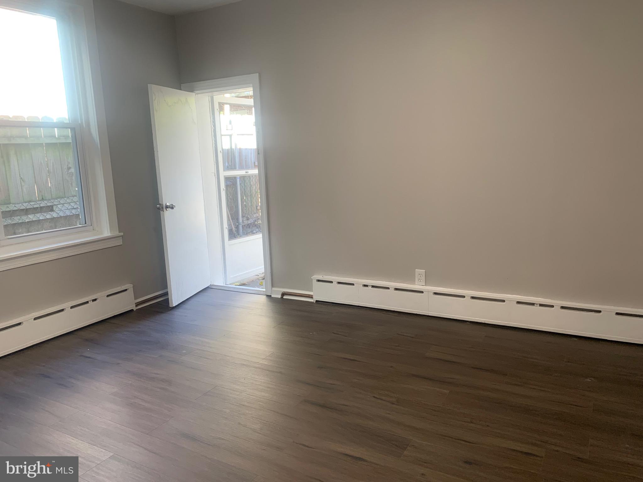 2387 Orthodox Street Philadelphia, PA 19137 - Photo 9 of 13 an empty room with wooden floor and windows