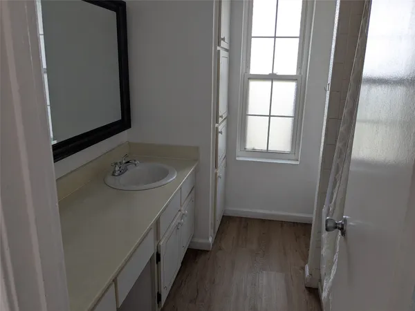 a bathroom with a sink and mirror with window