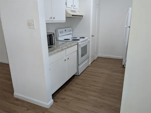 a kitchen with a stove top oven and cabinets