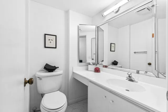 a bathroom with a sink toilet and a mirror