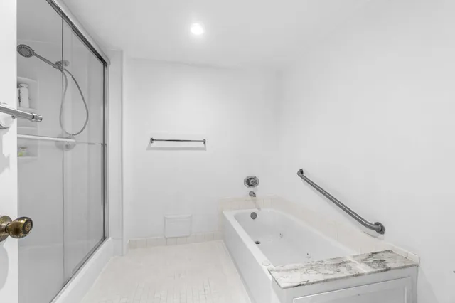 a bathroom with a tub a sink and a mirror