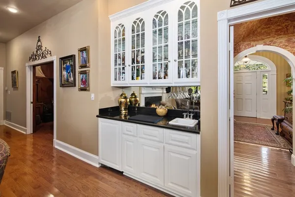a view of a hallway with wooden floor and a living room