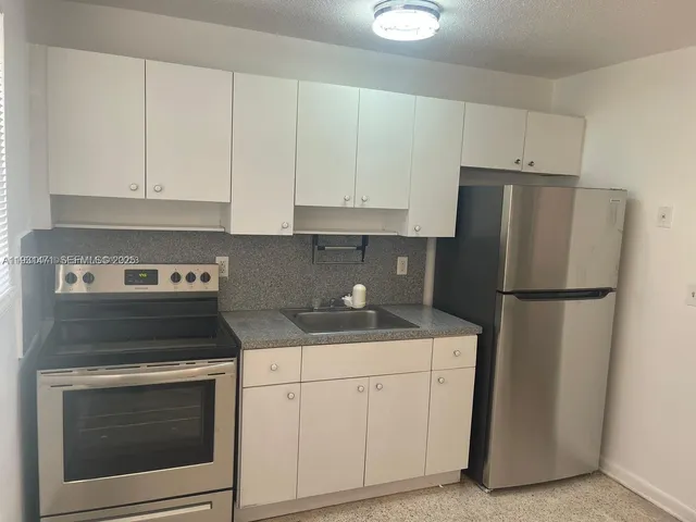 a kitchen with a stove cabinets and refrigerator
