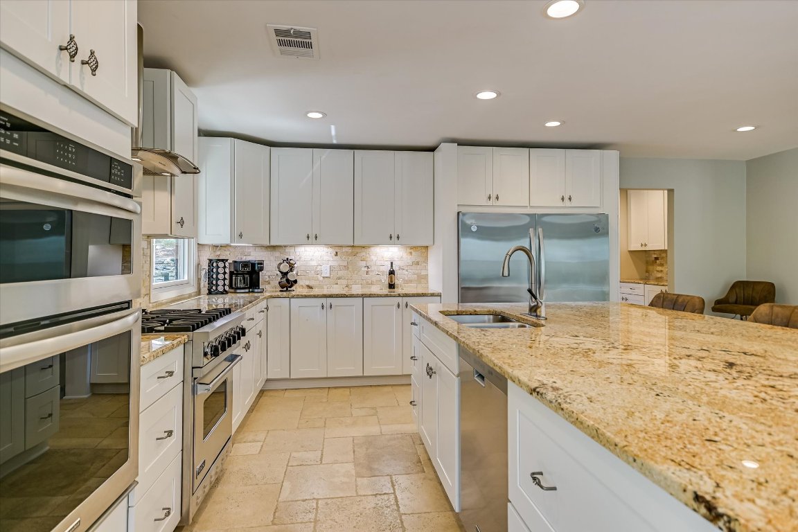 878 Ranch Road 2766 Johnson City, TX 78636 - Photo 9 of 40 a kitchen with granite countertop a sink stainless steel appliances and white cabinets