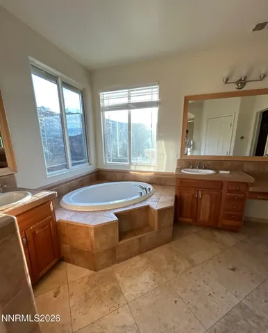 a bathroom with a tub sink and mirror