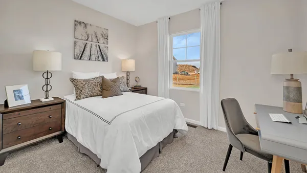 a bedroom with a bed and a chair in it