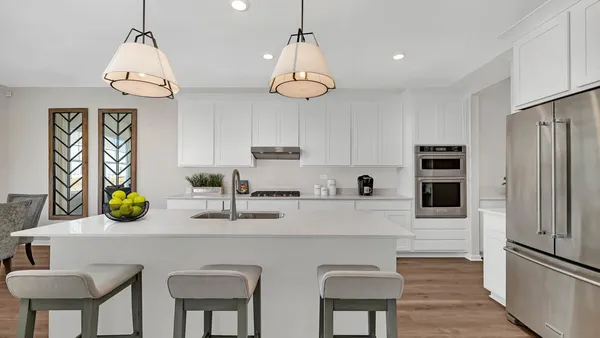 a kitchen with stainless steel appliances a table chairs refrigerator and microwave