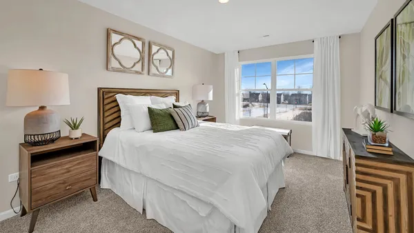 a bedroom with a bed and a potted plant