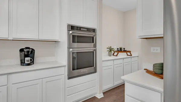 a kitchen with white cabinets and white appliances