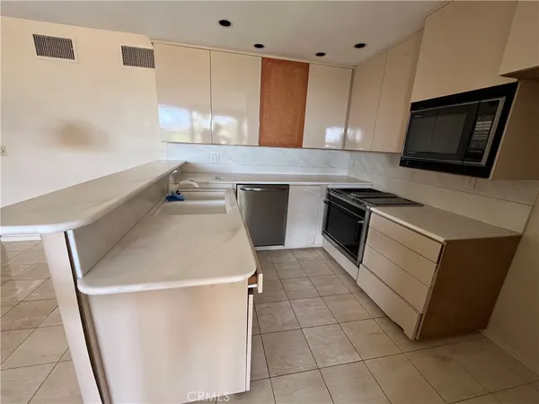 a kitchen with a sink a microwave and cabinets