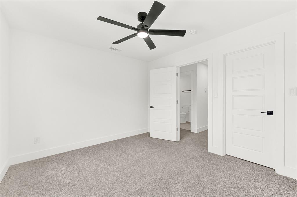 9471 Timberleaf Drive Dallas, TX 75243 - Photo 23 of 39 Carpeted interior room featuring a modern ceiling fan with integrated lighting, crisp white walls, and contemporary panel doors with matte black hardware
