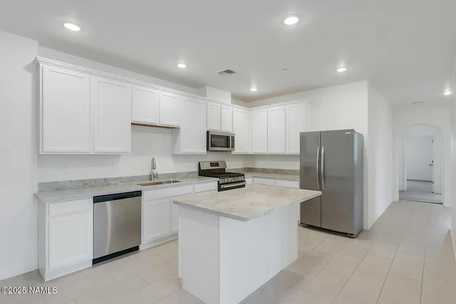 a kitchen with stainless steel appliances granite countertop a refrigerator sink stove and microwave