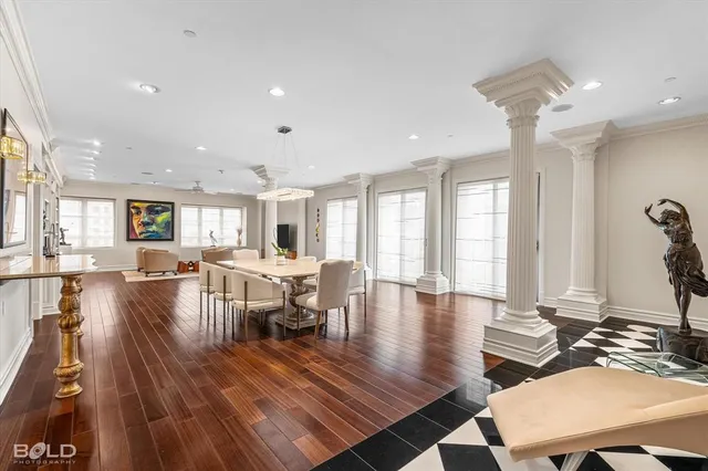 a dining room with wooden floor and large windows