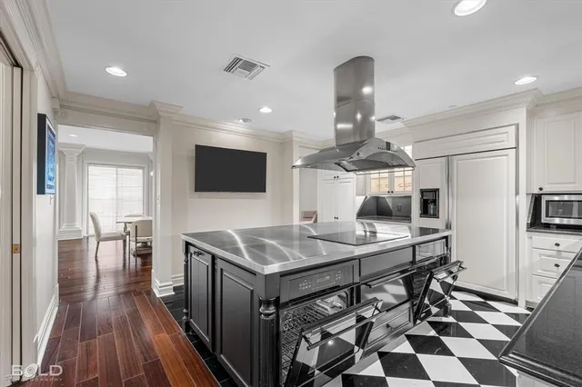 a kitchen with stainless steel appliances a dining table chairs and granite counter tops