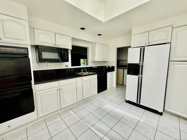 a kitchen with stainless steel appliances a refrigerator sink and microwave