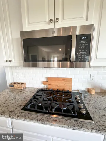 a white toilet sitting next to a white sink and vanity