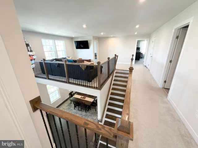 a living room with furniture a flat screen tv and windows
