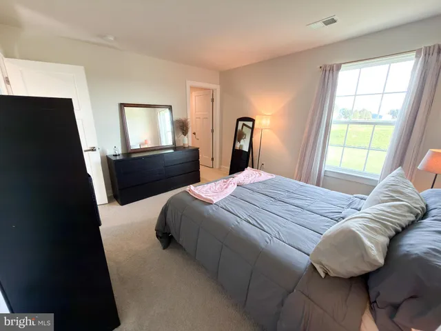 a bedroom with a bed and a painting on the wall